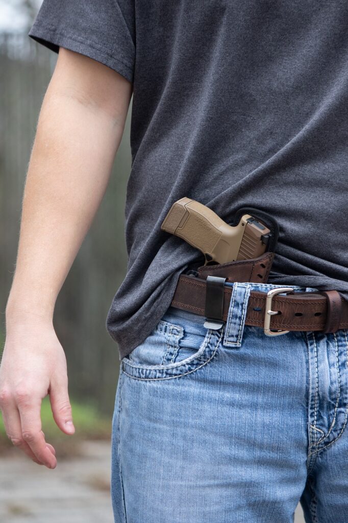 person caring gun in belt